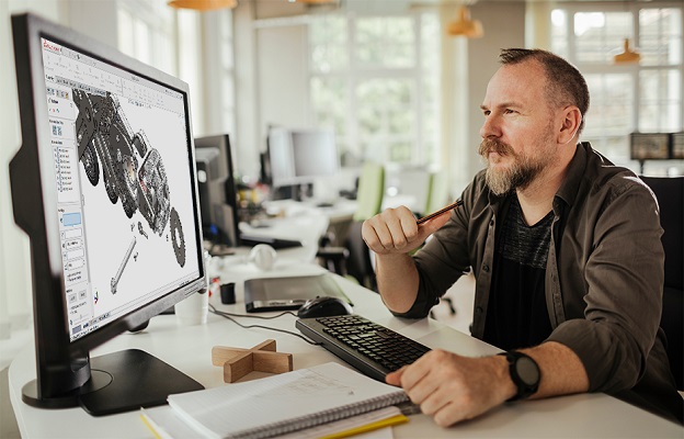 Worker studying a project on computer screens